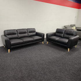 Pearl 3 Seater and 2 Seater Black Sofa Set on display in The A2Z Furniture showroom, the three-seater and two-seater facing each other, both in black leather on pale tapered timber legs