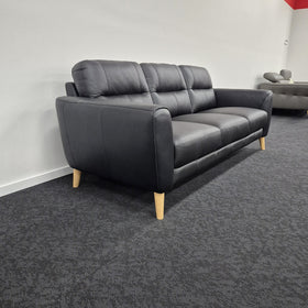 Pearl 3 Seater Leather Lounge in black leather, angled side view showing the pillow-top armrest, side profile and splayed timber legs, in The A2Z Furniture showroom