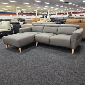Penelope 3 Seater Leather Lounge with Chaise in Anthracite, three-quarter view from the chaise end with the adjustable headrests raised, in The A2Z Furniture showroom.