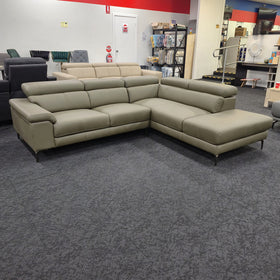 Penguine Leather Corner Chaise Sofa in olive leather, three-quarter view showing the chaise and slim dark metal legs, at The A2Z Furniture showroom
