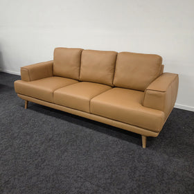 Picasso 3 Seater Leather Lounge in Orange leather, angled side view showing the low-profile silhouette and splayed walnut-coloured wooden legs, in The A2Z Furniture showroom.