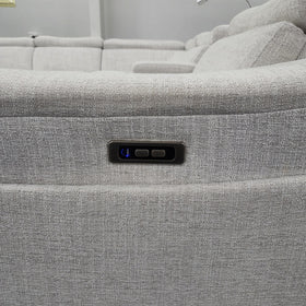 Close-up of the Sandgate Electric Corner Recliner Lounge in light grey fabric showing the two-button electric recline control and illuminated USB charging port set into the side panel