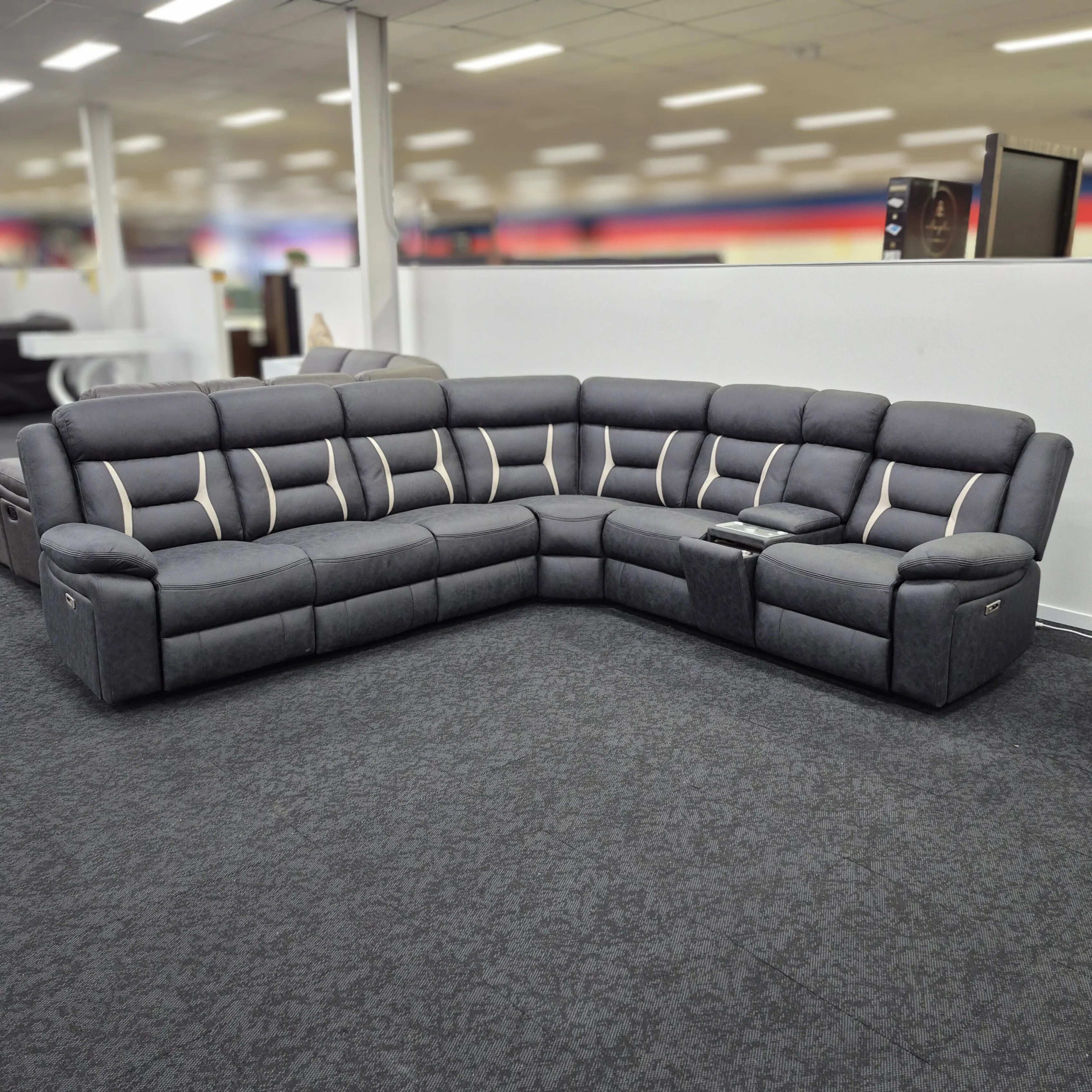 Grey fabric electric corner recliner lounge with cup holders in showroom