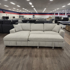 Seaford Corner Sofa Bed in Light Grey with the pull-out bed fully extended, photographed front-on in the showroom.
