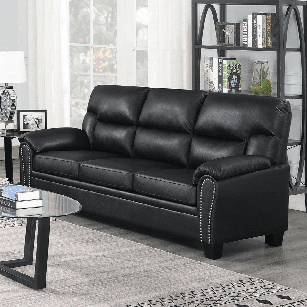 Black leather sofa with studded arms in a modern living room setting