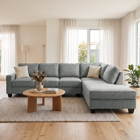 Signature II corner sofa with chaise in dark grey fabric, chaise on the left when sitting, with two throw cushions, styled in a bright living room