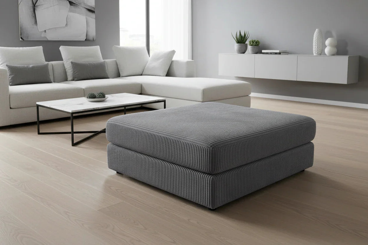 Gray ottoman in a modern living room with a sectional sofa and coffee table.