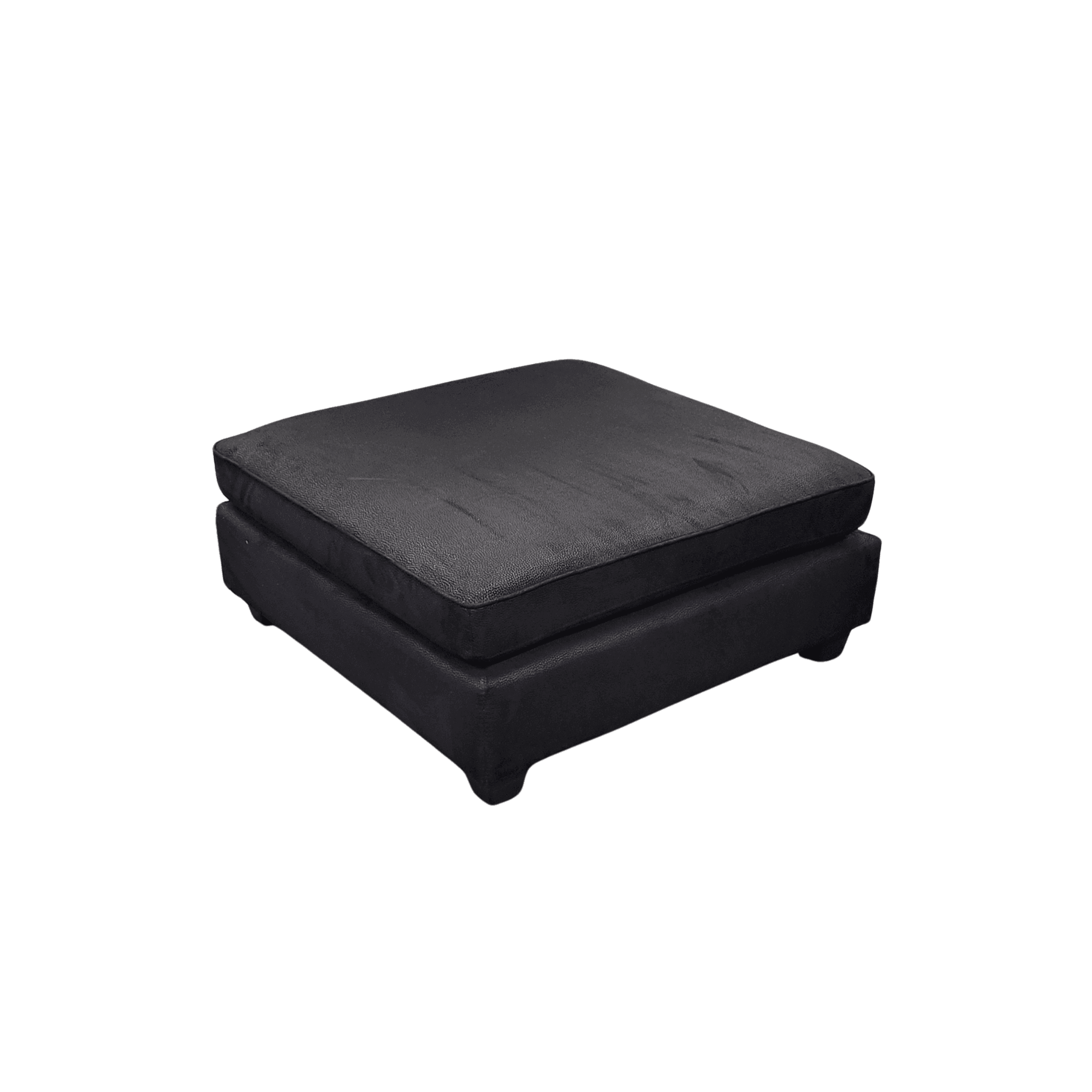 Black square ottoman with plush black fabric in a modern living room.