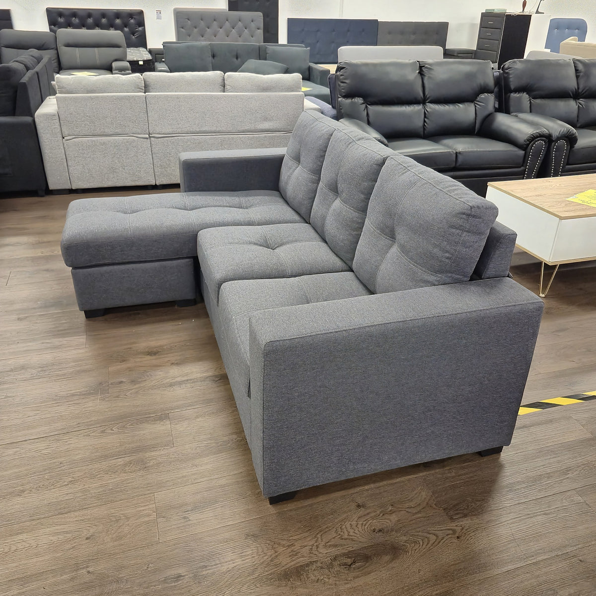 Sleek 3 Seater Chaise Lounge in dark grey fabric, rear three-quarter view showing the finished back, in The A2Z Furniture showroom