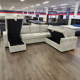 Springbrook Corner Sofa Bed in Grey with both lift-up storage compartments open, showing the storage space beneath the chaise and the corner seat.