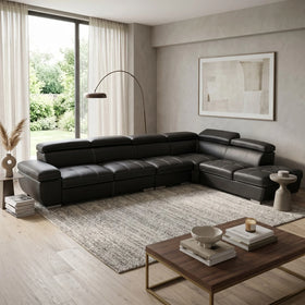 Modern living room with a black sectional sofa and wooden coffee table.