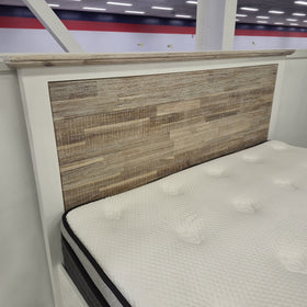 Detail view of the Tasman Storage Bed Frame's off-white frame and headboard corner with mattress in The A2Z Furniture showroom (mattress shown not included).