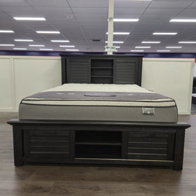 Warwick Bookcase Bed Frame in dark timber finish, full showroom view showing headboard bookcase shelving and footboard storage shelf, at The A2Z Furniture showroom. Mattress shown is not included.